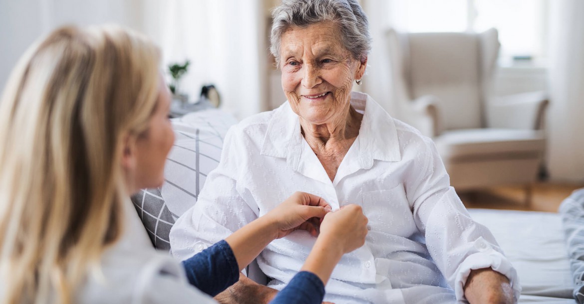Compassionate Home Health Aide assisting an elderly person with daily activities at home.