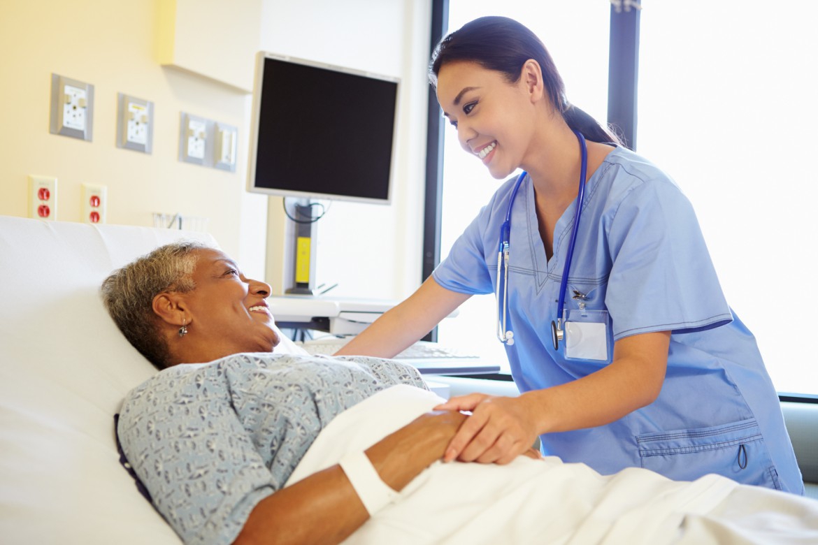 A caring home healthcare professional providing support to a patient at home.